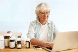 Older adult Woman researching Medigap coverage options on a laptop at C